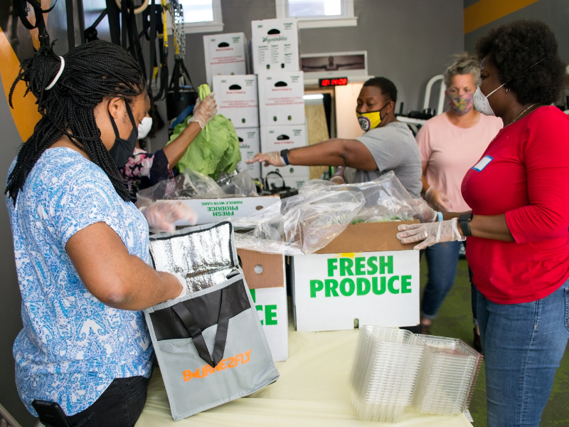 People packing produce into food bags at Bourne2Fly Fitness in Washington, DC